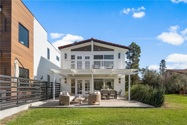 rear view of house featuring an outdoor living space, a balcony, a patio area, and a lawn