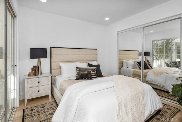 bedroom with light hardwood / wood-style flooring and a closet