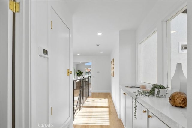 hallway with a wealth of natural light and light hardwood / wood-style floors