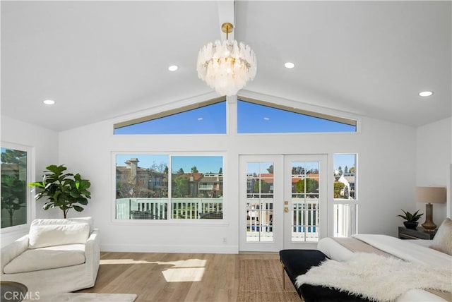 bedroom featuring lofted ceiling, french doors, access to exterior, a notable chandelier, and wood-type flooring