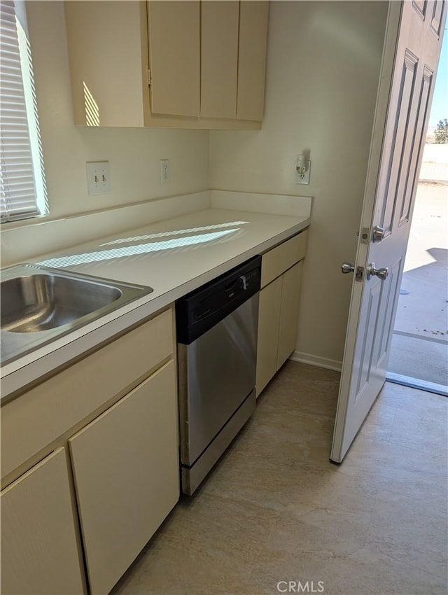 kitchen featuring stainless steel dishwasher, sink, and cream cabinets