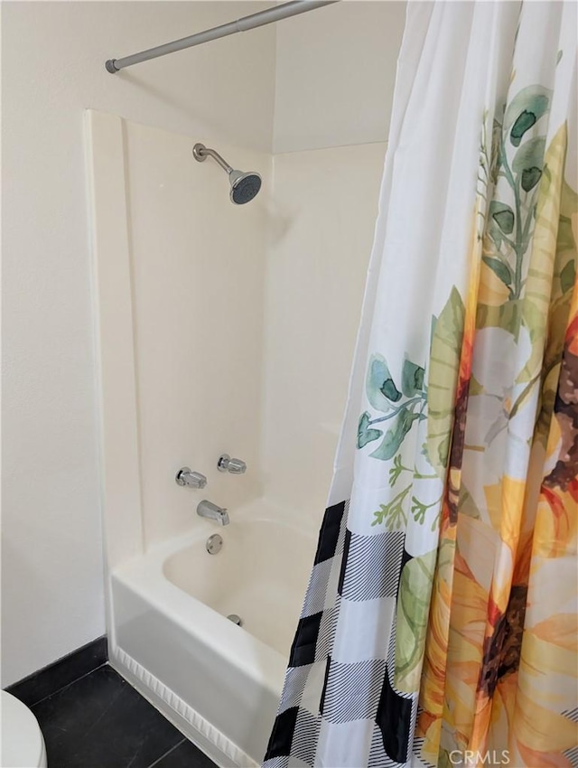 bathroom with shower / bath combo with shower curtain and tile patterned flooring