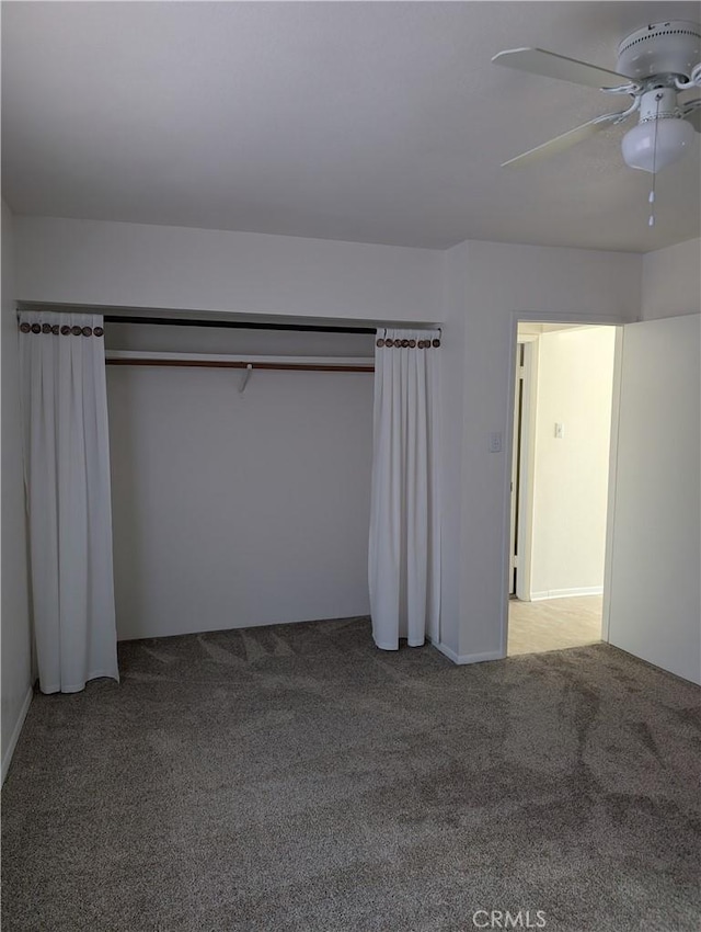 unfurnished bedroom featuring ceiling fan, a closet, and carpet floors