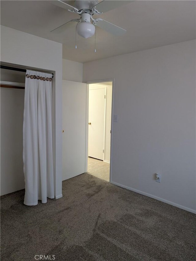 unfurnished bedroom featuring a closet, light colored carpet, and ceiling fan