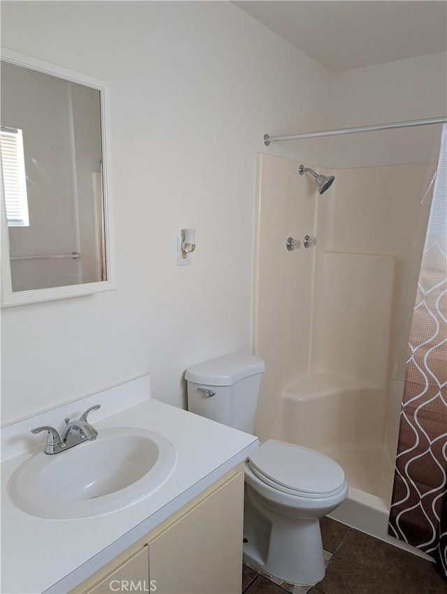 bathroom featuring tile patterned flooring, a shower with curtain, vanity, and toilet