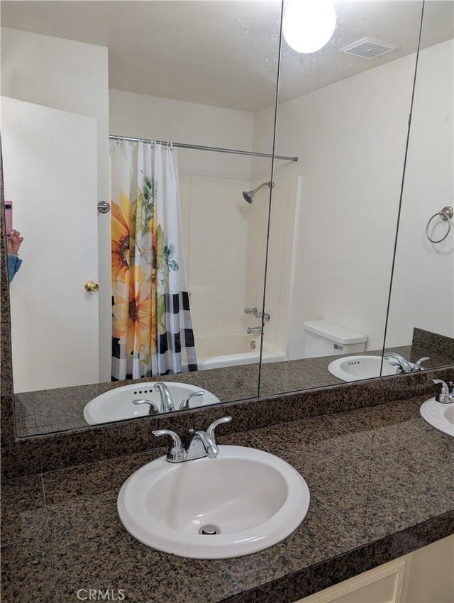 full bathroom featuring toilet, vanity, and shower / tub combo with curtain