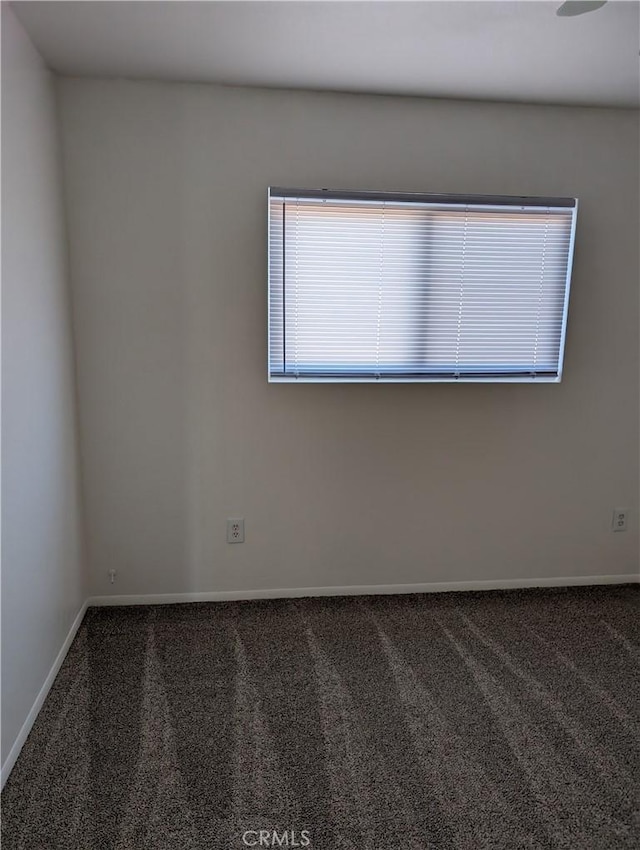 unfurnished room featuring dark colored carpet