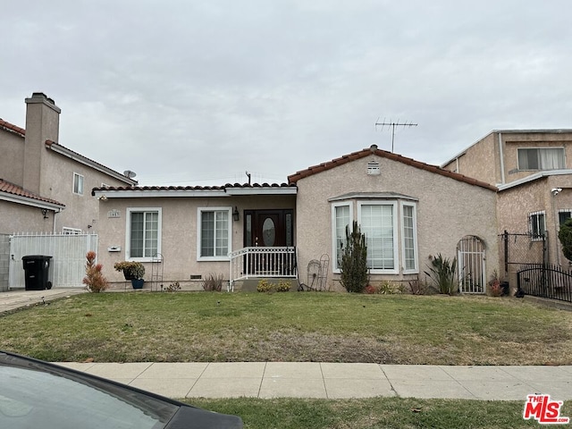 mediterranean / spanish house featuring a front yard