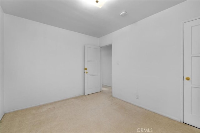 spare room featuring light colored carpet