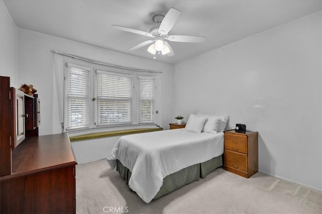 bedroom with light carpet and a ceiling fan