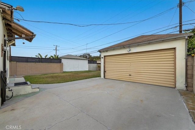 detached garage featuring fence