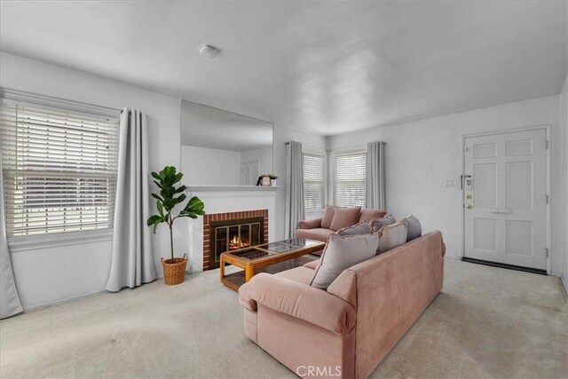 carpeted living room featuring a healthy amount of sunlight and a fireplace