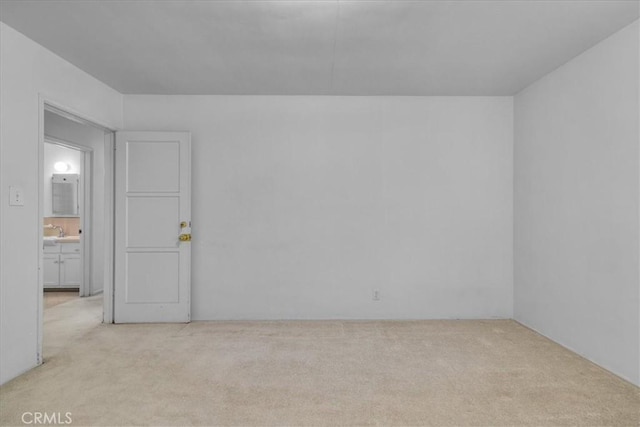 empty room featuring a sink and light colored carpet