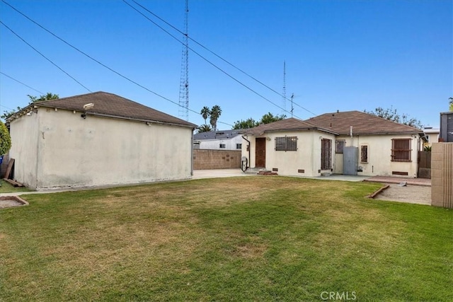 back of house featuring a patio area, fence, a lawn, and stucco siding