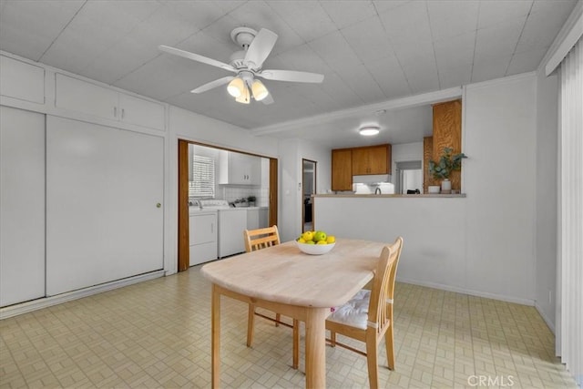 dining space with a ceiling fan, independent washer and dryer, and baseboards