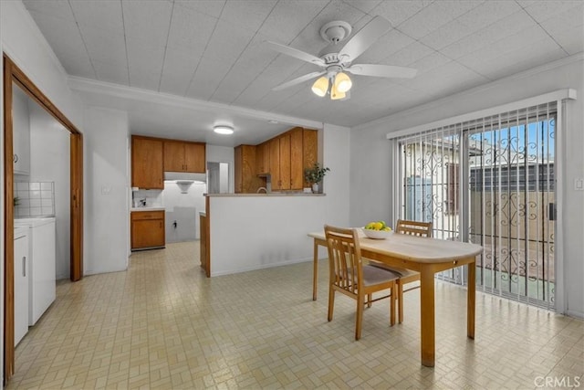 dining room featuring a ceiling fan, washing machine and dryer, and crown molding