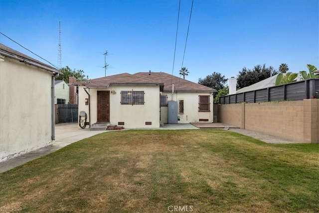 back of property with a lawn, a patio area, a fenced backyard, and stucco siding