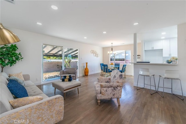 living room with dark hardwood / wood-style flooring and a chandelier