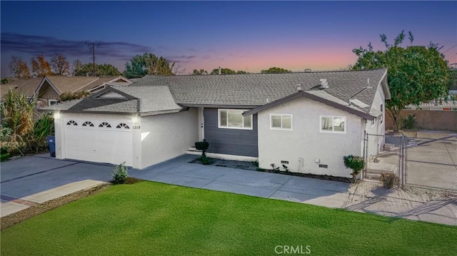 ranch-style house with a garage and a lawn