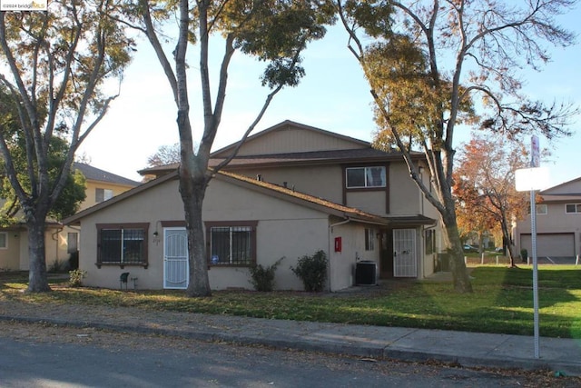 view of front of home with cooling unit and a front lawn