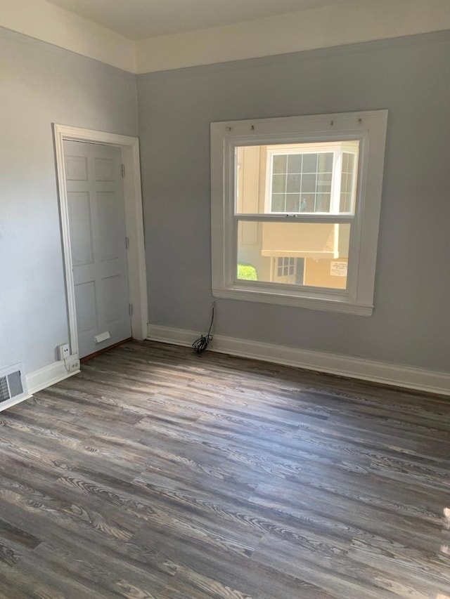 unfurnished room with dark wood-type flooring