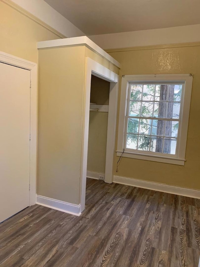 unfurnished bedroom featuring a closet and dark wood-type flooring