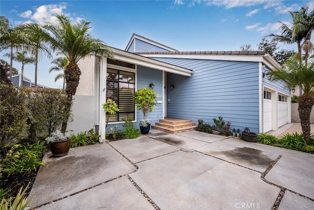 exterior space with concrete driveway and a garage