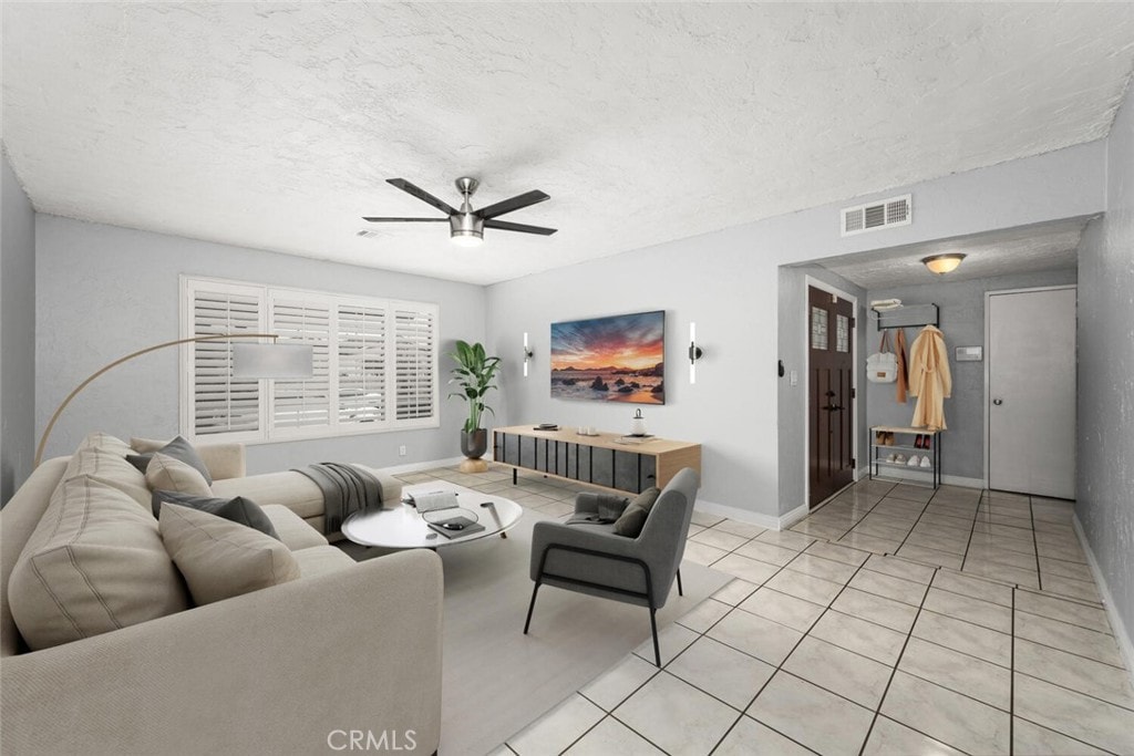 tiled living room featuring a textured ceiling and ceiling fan