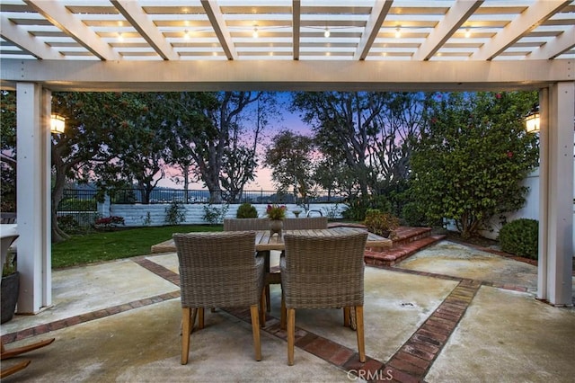 patio terrace at dusk featuring a pergola