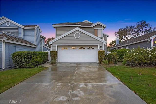 front facade featuring a garage and a yard