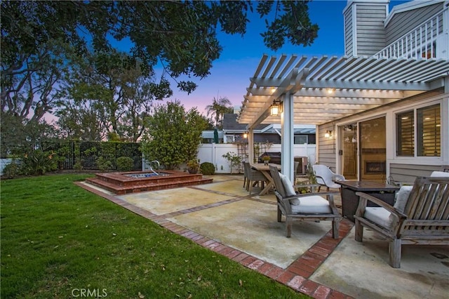 patio terrace at dusk with a fire pit, a pergola, and a yard