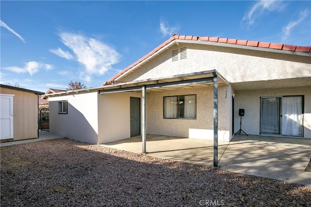 back of property featuring a patio area and a shed