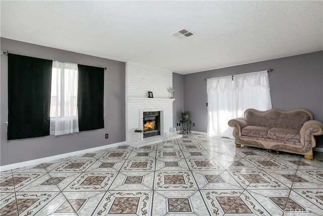 living room featuring a textured ceiling and a brick fireplace