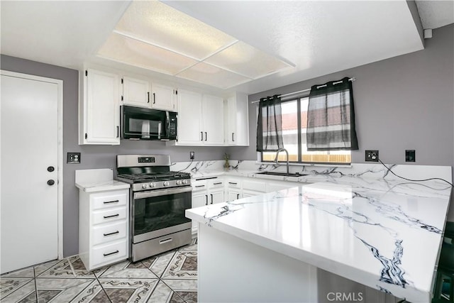 kitchen featuring gas stove, kitchen peninsula, sink, and white cabinets