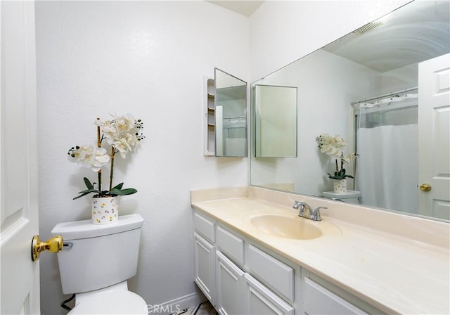 bathroom featuring walk in shower, vanity, and toilet