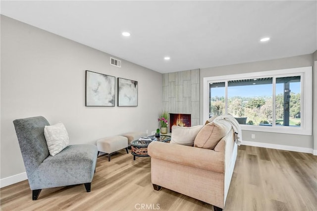 living room with light wood-type flooring and a fireplace