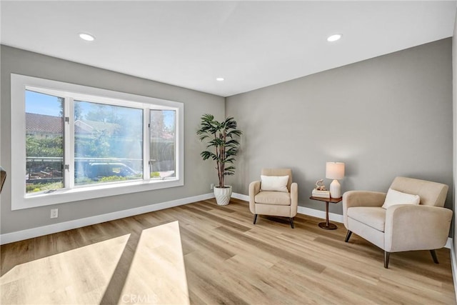 living area featuring a wealth of natural light and light hardwood / wood-style flooring