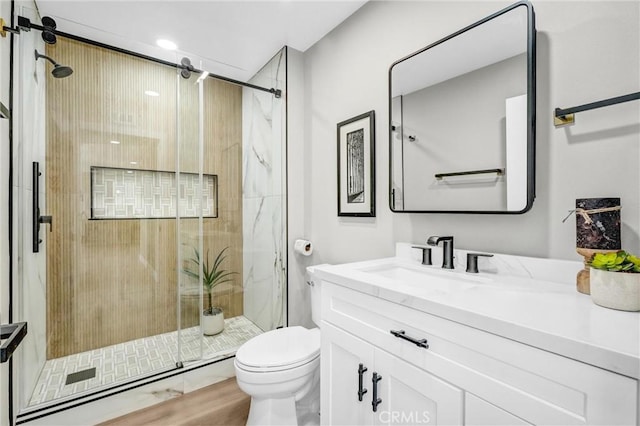 bathroom with an enclosed shower, vanity, wood-type flooring, and toilet