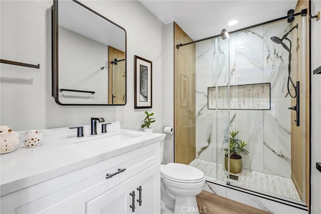 bathroom featuring vanity, toilet, and walk in shower