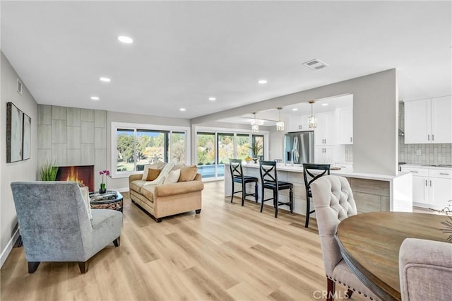 living room with light wood-type flooring and a fireplace