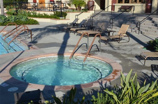 view of pool with a community hot tub and a patio area