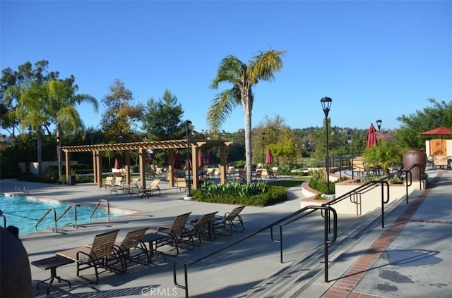 view of community with a pergola, a swimming pool, and a patio