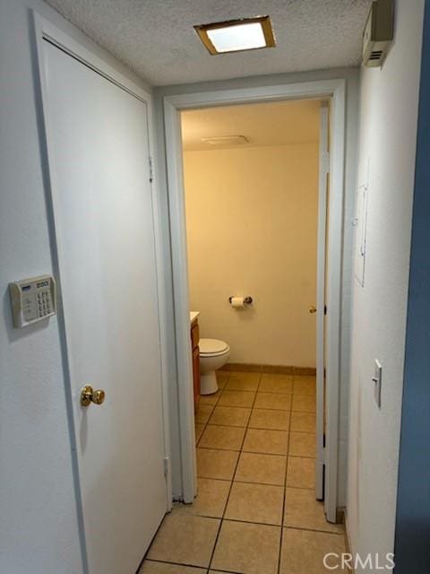 bathroom featuring tile patterned floors, toilet, a wall mounted air conditioner, and a textured ceiling