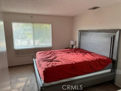 carpeted bedroom featuring a textured ceiling