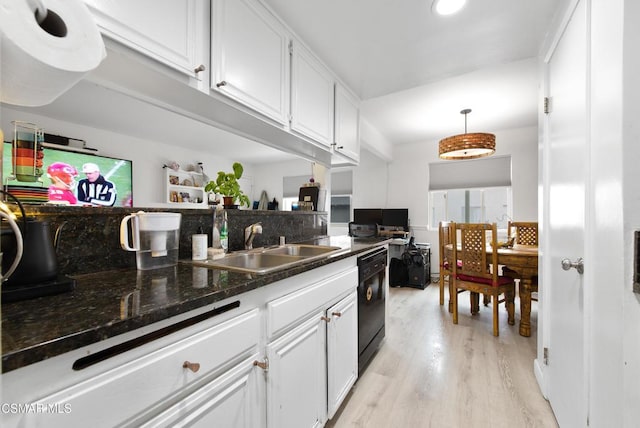 kitchen featuring sink, decorative light fixtures, light hardwood / wood-style flooring, black dishwasher, and white cabinetry