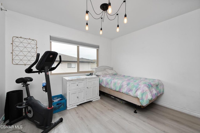 bedroom featuring a chandelier and light hardwood / wood-style floors