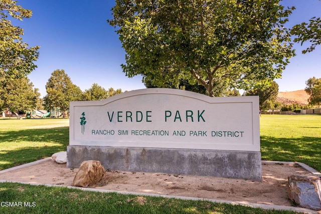 community sign featuring a mountain view and a yard