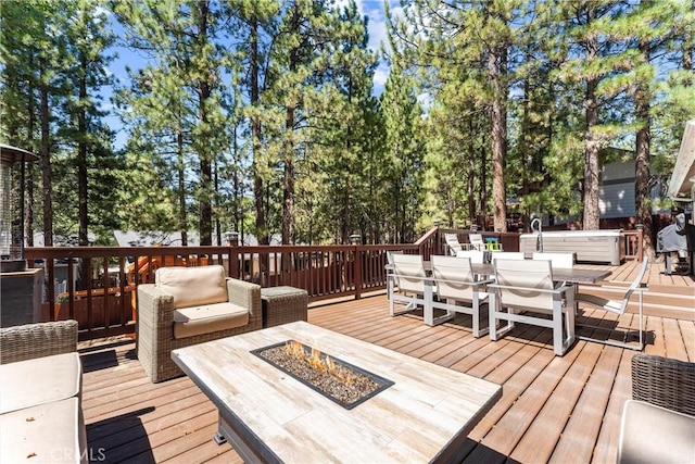 wooden terrace featuring an outdoor fire pit and a hot tub