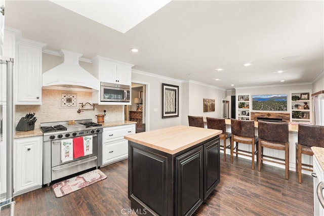 kitchen with dark hardwood / wood-style flooring, a kitchen island, stainless steel appliances, and custom exhaust hood