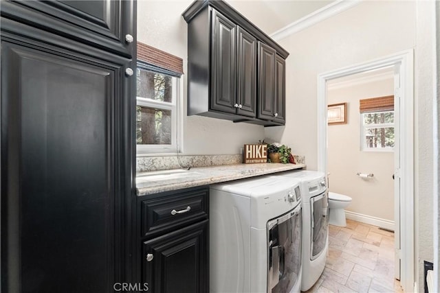 laundry area with cabinets, ornamental molding, and washing machine and clothes dryer